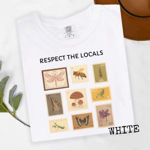 May include: White t-shirt with the text "RESPECT THE LOCALS" and various vintage-style postage stamp designs featuring insects, plants, and a bird. The word "WHITE" is printed at the bottom right.