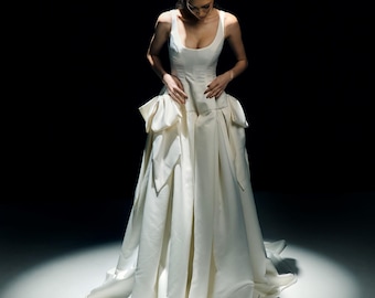 Vestido de novia victoriano de satén color marfil con lazos y cola larga. LIV