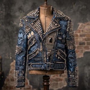May include: A blue leather motorcycle jacket heavily embellished with silver-toned metal spikes and studs. The jacket features various patches and printed text including 'CHAOS & CHAOS', 'DANZIG', 'HORROR PUNK', and 'DRAGON BORN', along with skull graphics.