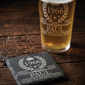 Puede incluir: Un vaso de cerveza transparente y un posavasos cuadrado de pizarra negra, ambos grabados con el texto 1966, Paul, Aged to Perfection, Limited Edition y One of a Kind, con un diseño de corona de laurel, estrellas y un motivo de corona.