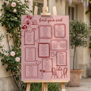 May include: A pink wedding seating plan displayed on an easel. The chart has a decorative border and the words "find your seat". Illustrations of tables, hearts, and couples are included in the design.