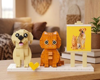May include: A brick-built toy set featuring a tan dog figure, an orange tabby cat figure, and a yellow heart on a white base. Next to them stands a yellow easel displaying a photograph of a ginger cat and a golden retriever dog.