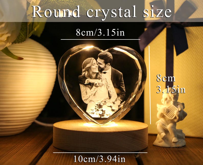 May include: A heart-shaped crystal with a photo of a couple, illuminated by a wooden base. The crystal measures 3.15 inches in height and width, and 3.94 inches in base length. The text on the image reads "Round crystal size".