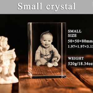 Może przedstawiać: Mały kryształowy blok z obrazem 3D dziecka. Blok ma wymiary 5 x 5 x 8 cm i waży 520 gram&oacute;w. U g&oacute;ry znajduje się napis "Small crystal".