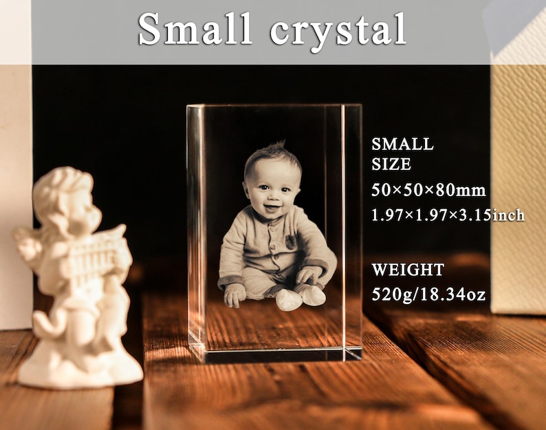 Może przedstawiać: Mały kryształowy blok z obrazem 3D dziecka. Blok ma wymiary 5 x 5 x 8 cm i waży 520 gram&oacute;w. U g&oacute;ry znajduje się napis "Small crystal".