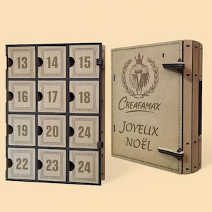 May include: A wooden advent calendar with numbered compartments, featuring the numbers 13-24. The open side displays the text "CREAFAMAX" and "JOYEUX NOËL" with a decorative emblem. The calendar is designed for the Christmas holiday season.