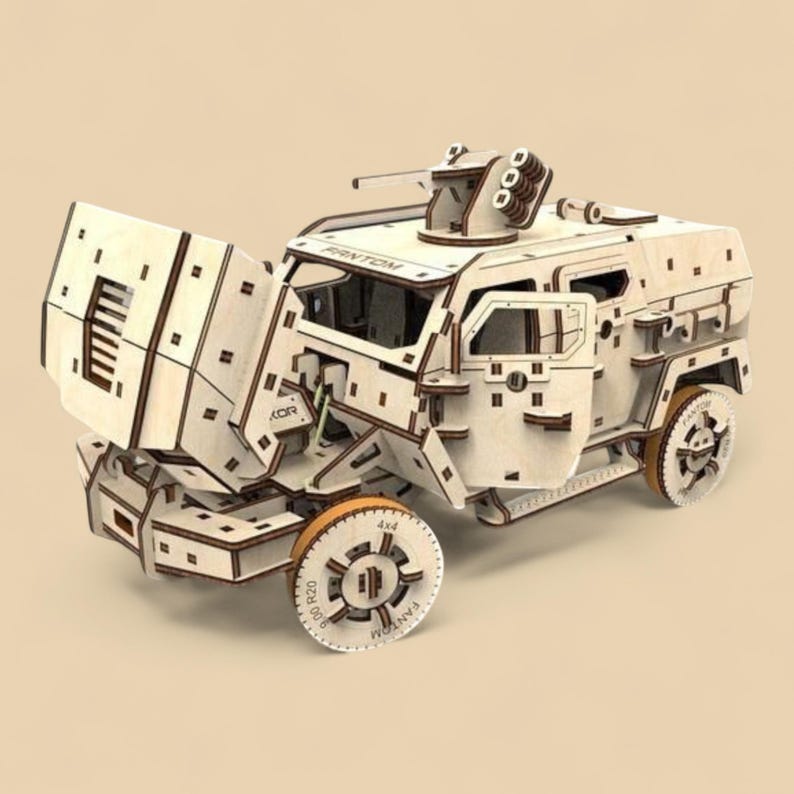 May include: A wooden model of a military vehicle with the hood open. The model is made of light-colored wood with dark brown accents. The wheels and other details are visible. The text "FANTOM" is visible on the wheels.