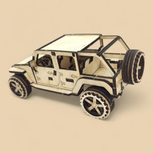 May include: A wooden model of a light-colored off-road vehicle with black accents. The model features detailed wheels, a spare tire, and an open-top design. The vehicle is approximately 6 inches long.
