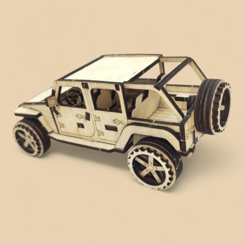 May include: A wooden model of a light-colored off-road vehicle with black accents. The model features detailed wheels, a spare tire, and an open-top design. The vehicle is approximately 6 inches long.