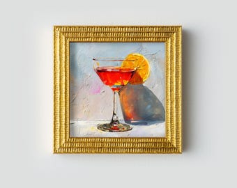 Peut inclure: Peinture à l'huile d'un cocktail dans un verre coupe avec une tranche d'orange, encadrée d'or. La boisson est rouge vif et la peinture a un style texturé et impressionniste. Le cadre est de couleur or chaud.