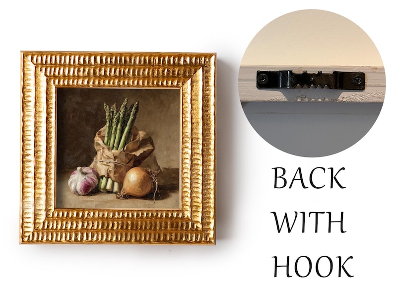 May include: A framed still life painting featuring asparagus, garlic, and an onion. The artwork is in a gold ornate frame. The back of the frame has a hook for hanging. The painting is a still life of fresh vegetables.