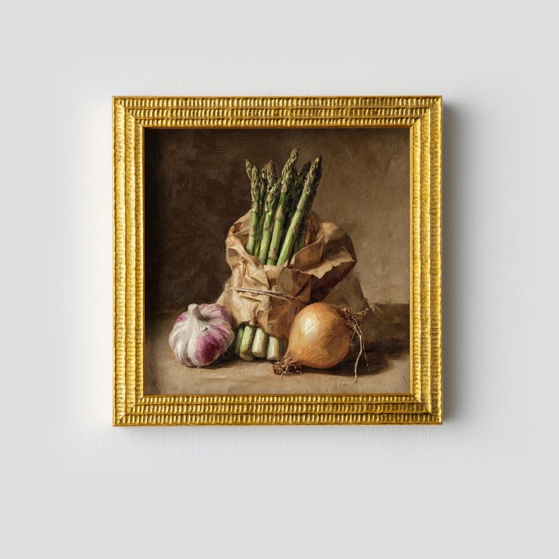May include: A framed still life painting featuring fresh asparagus in a paper bag, a bulb of garlic, and an onion. The painting has a warm color palette with a gold frame. The vegetables are arranged on a dark background.