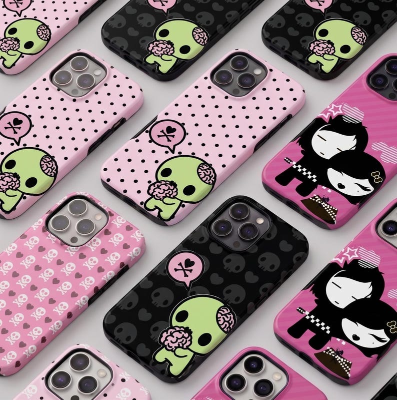 May include: A collection of phone cases with various designs. Some cases are pink with black polka dots or a pattern of skulls and hearts. Other cases are black with a skull pattern. Each case features a cartoon zombie character or a couple.