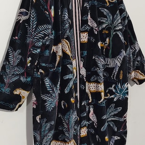 Puede incluir: Bata tipo kimono de terciopelo negro con un estampado de jungla vibrante con leopardos, cebras, p&aacute;jaros y palmeras. La bata tiene un forro interior a rayas.