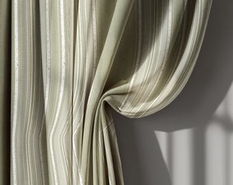 May include: Sage green and white striped curtain panels. The fabric has a textured appearance with vertical stripes of varying widths. The curtain is draped, with folds and shadows adding depth. The overall aesthetic is soft and natural.
