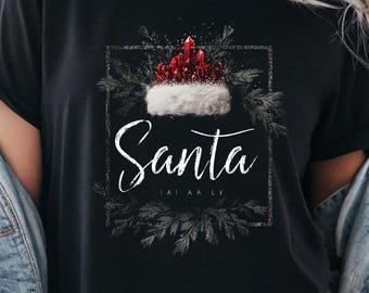 Camiseta navideña familiar de Papá Noel con gorro rojo festivo y vegetación festiva, camiseta negra para fiestas y regalos de invierno.