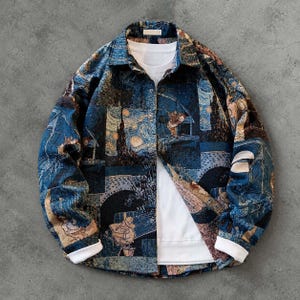 Puede incluir: Una camisa de manga larga con botones y un estampado azul oscuro de varios paneles con patrones en espiral y figuras. La camisa tiene un cuello clásico, botones de presión metálicos y puños blancos sobre una camiseta interior blanca.