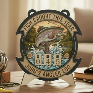 Puede incluir: Registro de pescador de madera con diseño circular. El centro presenta una trucha saltando sobre el agua, con el texto "FISH CAUGHT THIS YEAR" y "JOHN'S ANGLER LOG". El registro muestra el número "045".