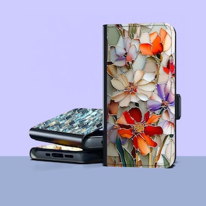 May include: A floral phone case with a stained glass effect. The case features a vibrant design of red, orange, white, and purple flowers. A second phone case with a mosaic tile design is visible in the background.