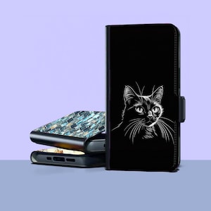 以下が含まれることがあります： 白い猫のイラストが描かれた黒い携帯電話ケース。ケースはマグネットクラスプで閉じられています。青と白のモザイクデザインの携帯電話ケースが2つ見えます。