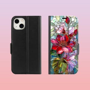 Peut inclure: &Eacute;tui de t&eacute;l&eacute;phone noir avec un motif floral. L'&eacute;tui est de style folio, avec une fermeture magn&eacute;tique. L'int&eacute;rieur pr&eacute;sente un motif floral color&eacute; de style vitrail avec des fleurs rouges, roses et violettes et des feuilles vertes.