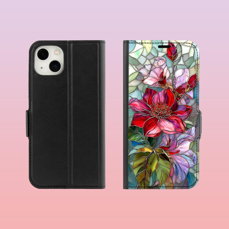 Peut inclure: &Eacute;tui de t&eacute;l&eacute;phone noir avec un motif floral. L'&eacute;tui est de style folio, avec une fermeture magn&eacute;tique. L'int&eacute;rieur pr&eacute;sente un motif floral color&eacute; de style vitrail avec des fleurs rouges, roses et violettes et des feuilles vertes.