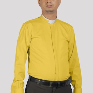 May include: A yellow long-sleeve shirt with a mandarin collar and white inner collar. The shirt is paired with dark gray pants and a black belt. The cuffs have a small, dark blue embroidered detail.