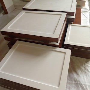 Puede incluir: Un juego de tres tazas de cerámica con un acabado moteado y mate. Las tazas son de color crema, gris claro y gris oscuro. Cada taza tiene un diseño simple y minimalista.