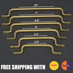 May include: Six brass-colored cabinet pulls in varying sizes: 10", 7", 5.5", 5", 4.3", and 3.5". Each pull has a curved handle with mounting holes on each end. The pulls are arranged in a descending order. The background is dark.