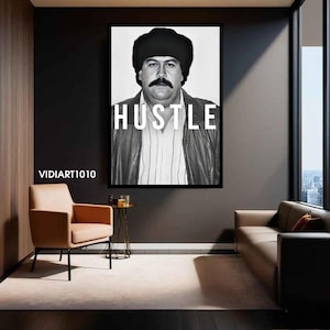 Könnte beinhalten: Schwarz-weiß gerahmtes Wandbild mit einem Porträt eines Mannes mit Schnurrbart und dem Wort "HUSTLE" in weißen Buchstaben. Der Mann trägt eine Lederjacke und einen Pelzhut. Das Kunstwerk wird in einem modernen Wohnzimmer ausgestellt.