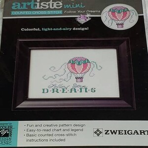 May include: A counted cross-stitch kit featuring a hot air balloon with the text "Follow Your Dreams". The kit is by Artiste Mini and Zweigart. The finished design size is 4.38 inches by 3.25 inches.