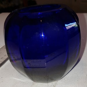 May include: A cobalt blue glass vase with a rounded shape and a textured surface.
