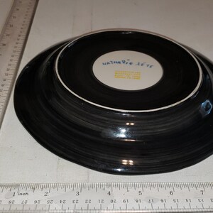 May include: Black and white ceramic plate with a blue and white logo that reads "Waterford  X-cite  Made in China".