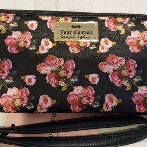 May include: Black wallet with a floral print and a gold zipper pull. The wallet has a gold logo that says "Juicy Couture Los Angeles, California".
