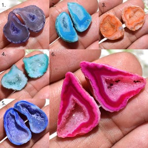 May include: Six pairs of polished agate geodes in different colours. The geodes are cut open, showing crystal-lined cavities. Colours include purple, blue, orange, turquoise, and pink. Each pair is displayed on a hand.