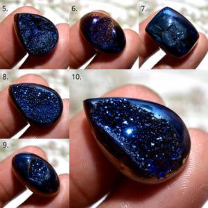 May include: A collection of polished, teardrop-shaped gemstones with a deep blue color and a sparkling, crystalline interior. The stones have a glossy, reflective surface, and the interior has a textured, rough appearance.