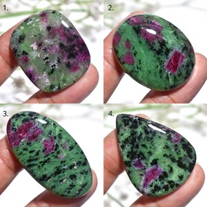 Puede incluir: Cuatro piedras preciosas pulidas de rubí zoisita. Cada piedra muestra una mezcla de tonos verdes, negros y magenta. Las formas varían de ovaladas a lágrimas, mostrando los patrones y colores naturales de los minerales.