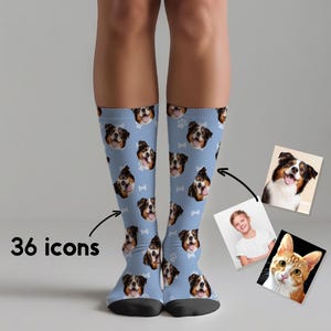 May include: Light blue crew socks featuring a repeating pattern of 36 dog face icons and small white bone shapes. The socks display a custom photo print of a dog's face, with additional reference photos of a dog and a cat shown to the side.