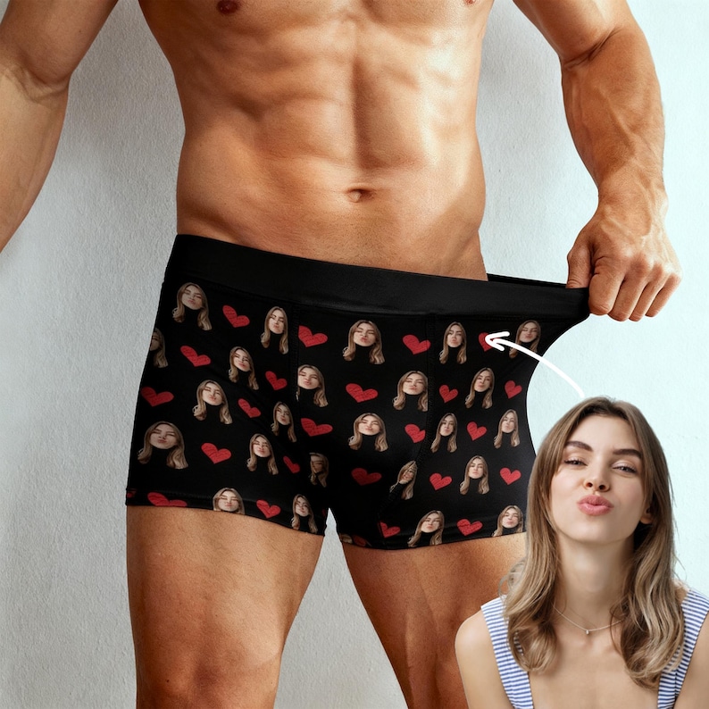 May include: Black boxer briefs with a repeating pattern of faces and red hearts. The underwear has a black waistband and is made of a soft, comfortable material. A fun and unique gift idea.