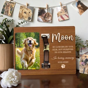 以下が含まれることがあります： ゴールデンレトリバーの写真、茶色の革の首輪、そして「Moon」という名前が入った木製のペットメモリアルフレーム。「私たちのそばにはもういないけれど、永遠に私たちの心の中に」と「愛情を込めて2015-2023」と書かれています。