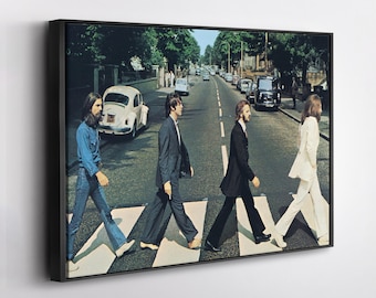 Puede incluir: Impresión enmarcada de la icónica portada del álbum Abbey Road. Cuatro figuras cruzan un paso de cebra en una calle de Londres. La imagen presenta un Volkswagen Beetle blanco y otros coches clásicos.