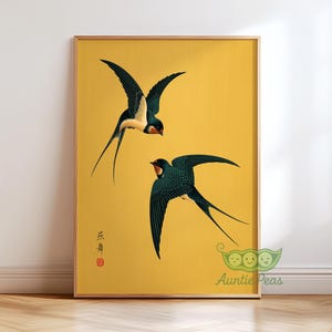 May include: A framed print featuring two swallows in flight against a yellow background. The swallows are depicted with dark green wings, white bellies, and red accents. The print has Japanese text and a red seal in the lower left corner.
