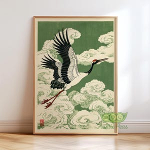 May include: A framed print featuring a Japanese crane in flight. The bird has black and white wings, a red head, and long legs, set against a green background with white clouds. The artwork is in a traditional style.