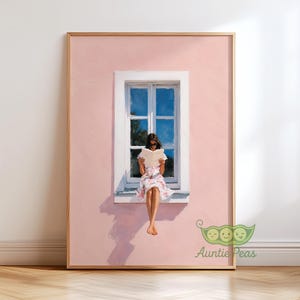 May include: A framed wall art print featuring a painting of a person sitting on a window ledge of a light pink building, reading an open book. The person wears a floral dress and sunglasses. The window frame is white, and the sky is visible.