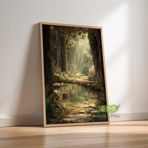 May include: A framed art print depicts a serene forest scene. Sunlight streams through the trees, illuminating a path alongside a calm stream. The artwork features lush greenery, water lilies, and a natural color palette.