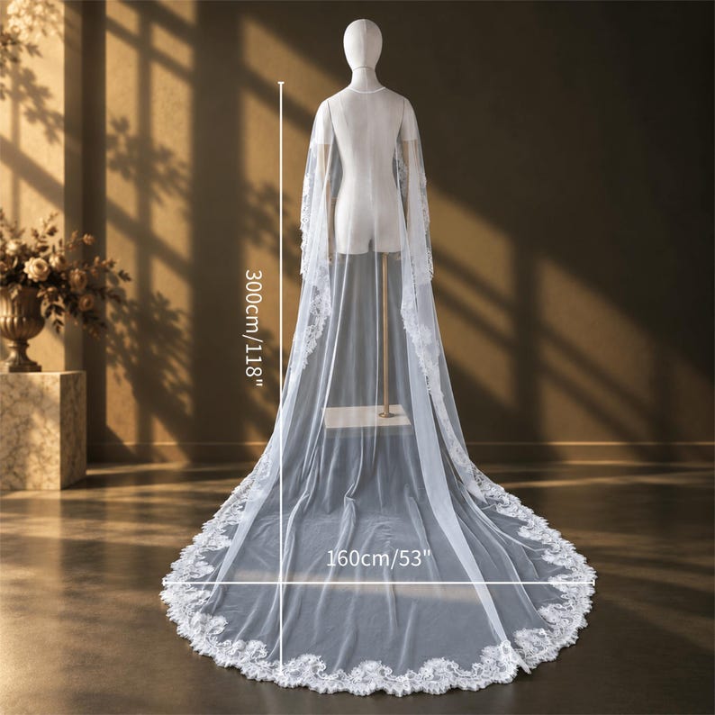 May include: A long white bridal veil with intricate lace trim along the edges, displayed on a mannequin. The veil measures 300cm/118 inches in length and 160cm/63 inches in width, featuring a sheer fabric that drapes to the floor in a train.