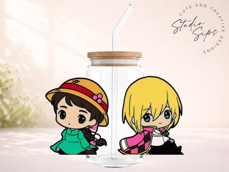 May include: Clear glass tumbler with a wooden lid and a curved glass straw. The tumbler features two cartoon character stickers. One character wears a green dress and a yellow hat with a red band. The other character has blonde hair and a pink and black cape. The text "Cute and Creative Studio Sips Designs" is in the upper right corner.