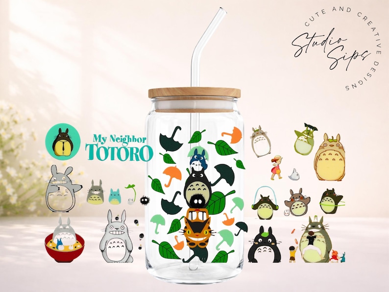 May include: A clear glass tumbler with a wooden lid and a glass straw, decorated with various Totoro character illustrations and green leaves. The tumbler has the text "My Neighbor Totoro" on it.
