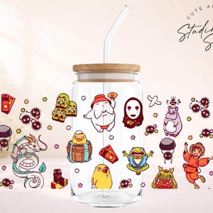 May include: A clear glass tumbler with a bamboo lid and a glass straw. The tumbler is decorated with colorful cartoon characters. The words "Cute and Creative Studio Sips Designs" are written in a script font.
