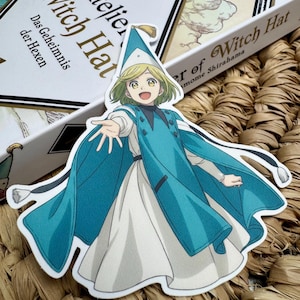 Könnte beinhalten: Ein gestanzter Aufkleber mit einem Anime-Charakter in einem blau-weißen Outfit und Hut. Der Aufkleber stammt von "Atelier Witch Hat" und "Das Geheimnis der Hexen". Der Charakter lächelt und streckt die Hand aus.